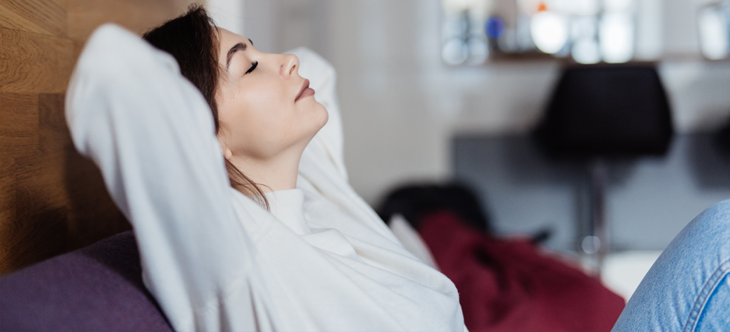 photo d'une femme décontracté sur un canapé les bras derriere la tete et les yeux fermés - blog